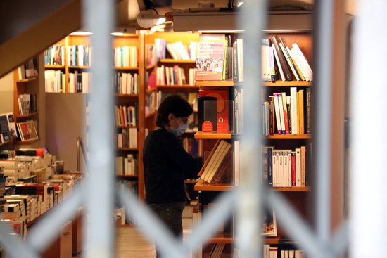 A bookseller behind closed doors on Sant Jordi 2020 as Barcelona's Laie and all other bookshops have had to remain shut due to the coronavirus lockdown (by Pere Francesch)